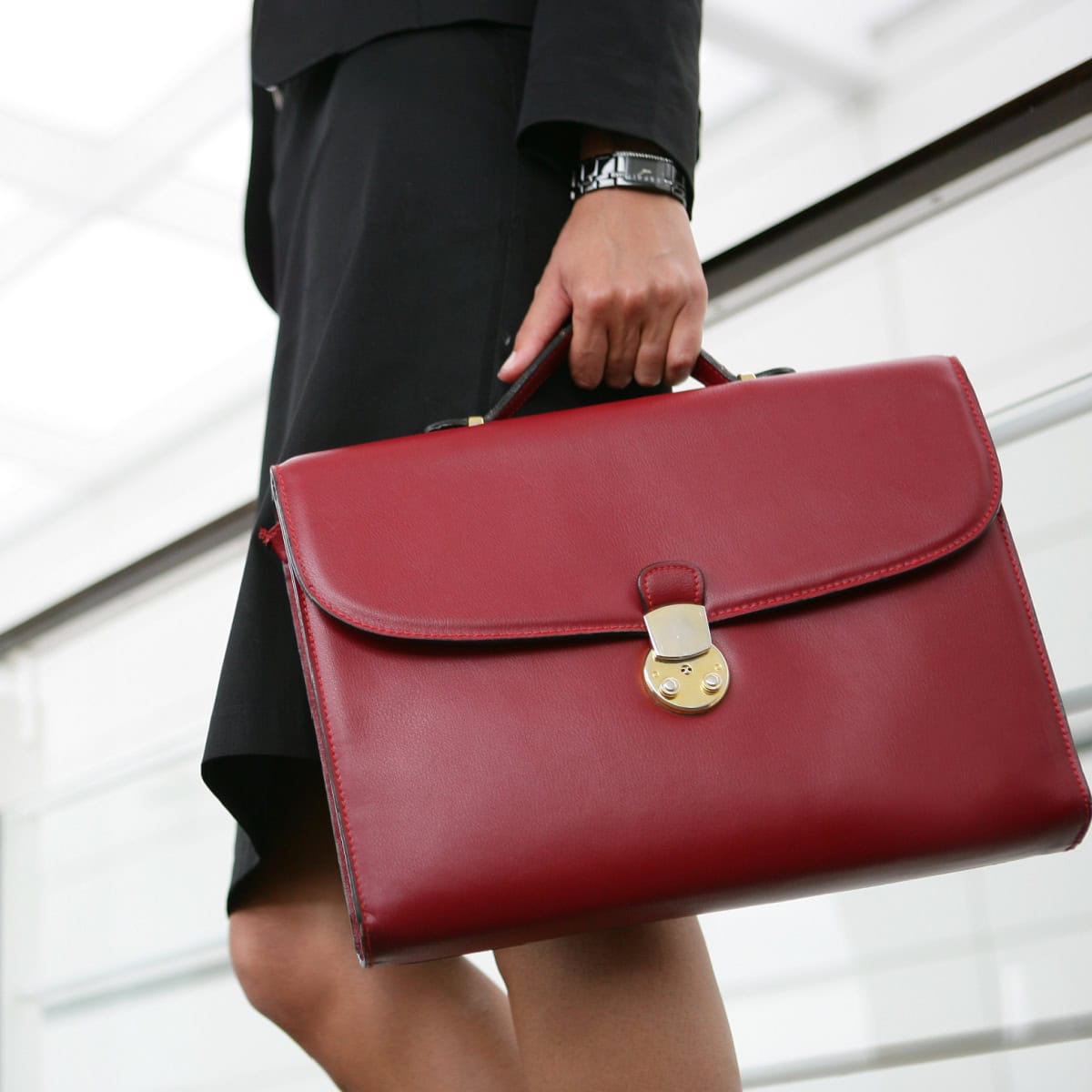 stylish professional woman carries a red briefcase