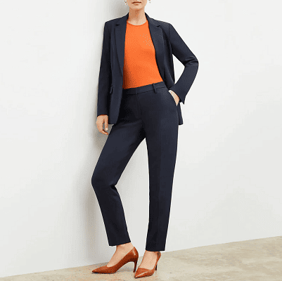woman in navy suit wears orange top and brown shoes with it