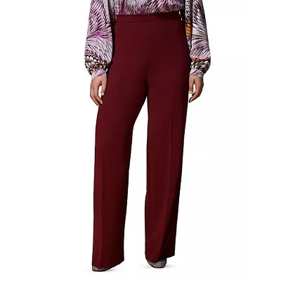 A woman wearing a print blouse and burgundy pants