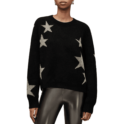 woman wears black sweater with metallic stars on it; she is also wearing shiny faux leather pants