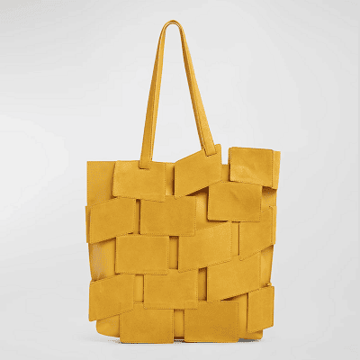 yellow tote with suede patchwork cutouts that look like they're floating on top of the bag