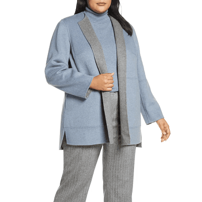 plus-sized professional woman wears light blue turtleneck and light blue hip-length cardigan jacket; the jacket has gray lapels because it reverses to gray. 