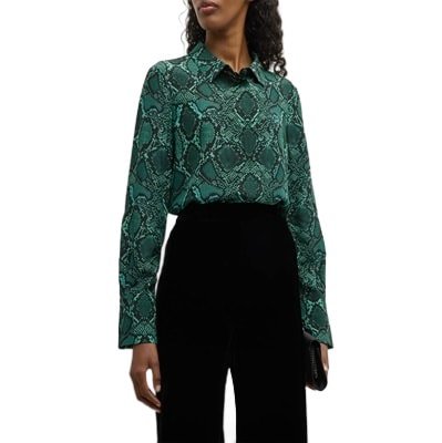 A woman wearing a green snakeskin-print blouse and black pants