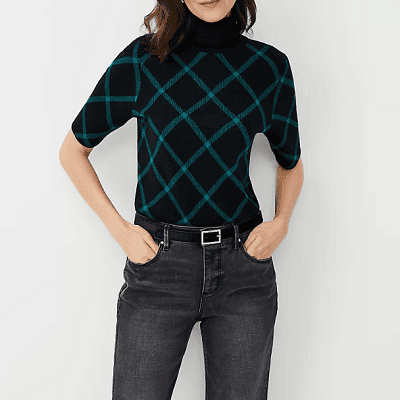 A woman wearing plaid turtleneck sweater and ash grey pants