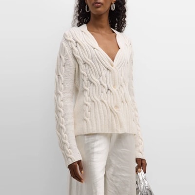 A woman wearing an ivory sweater and white pants