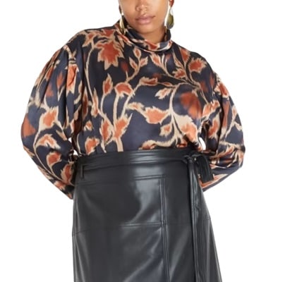 A woman wearing a navy print top and black leather skirt