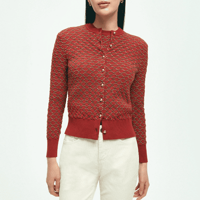 A woman wearing a Brooks Brothers red cardigan with gold buttons and white pants