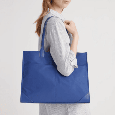 professional woman carries lightweight nylon tote in a pretty oxford blue