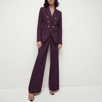 woman wears dark purple suit with double-breasted blazer and silver buttons