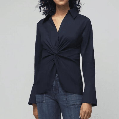 A woman wearing a White House Black Market dark blue top and denim pants