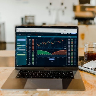 laptop computer monitor shows stock charts