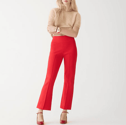 woman wears red sweater pants, red Mary Jane heels, and beige short-sleeved sweater with gold jewelry