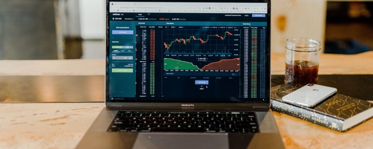laptop computer monitor shows stock charts