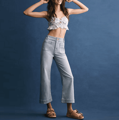 cropped wide-leg jeans; woman wears with a cropped bra top and ugly sandals