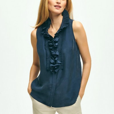 A woman wearing a dark blue short silk ruffle sleeve blouse