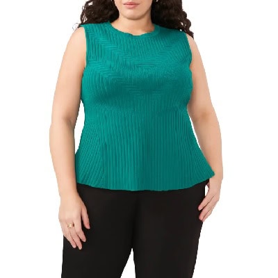 A woman wearing a green short sleeve tank top and black pants