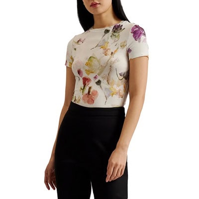 A woman wearing a floral tee and black pants