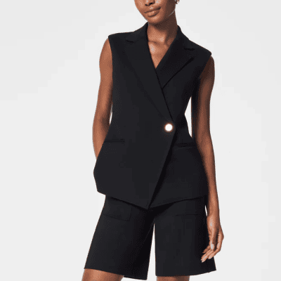 woman wears long black asymmetrical vest with matching shorts