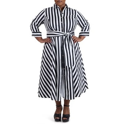 A woman wearing a black-and-white striped long-sleeve dress and black platform sandals