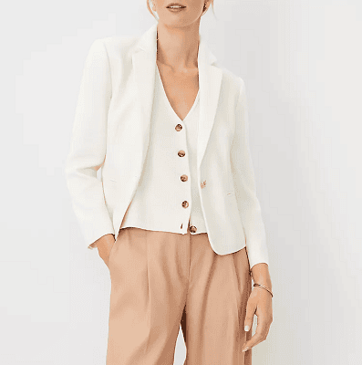 woman wears lightweight cotton blend blazer with white vest and beigey tan pants