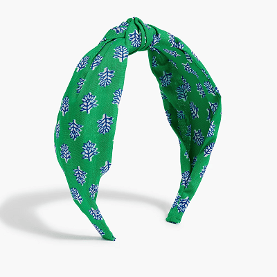 cloth headband with knot at top; the print is green with a tiny blue and white tree-shaped repeating pattern