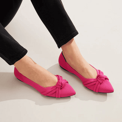 woman wears hot pink pointy-toed flats with a knotted detail on top