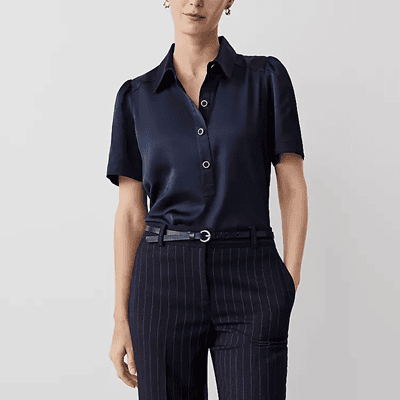 woman wears navy polo top with white buttons and a blousy look