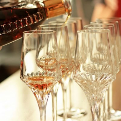 dark liquid being poured into fancy glasses (possibly cordial glasses)