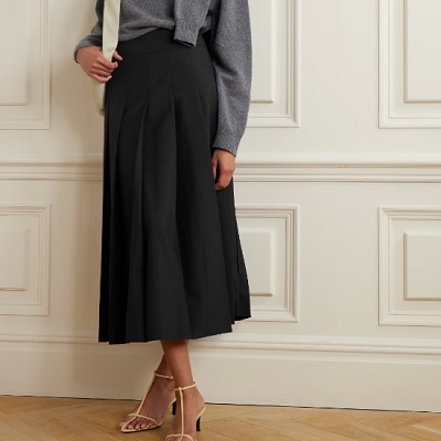 A woman wearing a gray long sleeve top and black midi wrap skirt with cream heels sandal