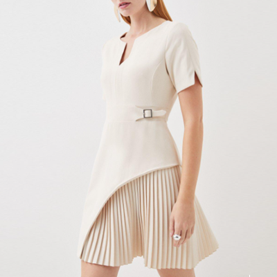 white dress with notched V-neck and a half-pleated skirt