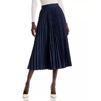 A woman wearing a white long-sleeve top and dark blue pleated skirt with cream-colored pumps