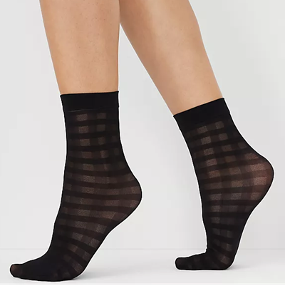 une femme porte des chaussettes transparentes avec un motif quadrillé