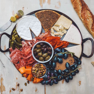 charcuterie tray with cheeses, fruit, olives, pickles, nuts, and meats