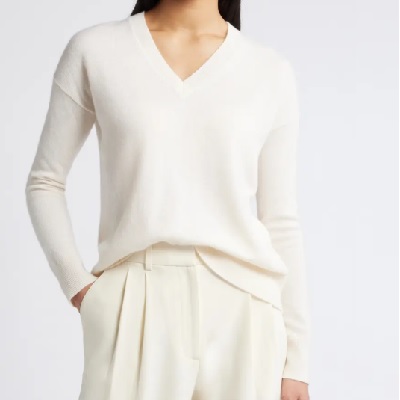 A woman wearing an ivory sweater and ivory pants