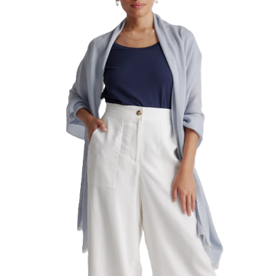 woman wears cashmere fringed scarf pashmina on top of a blue blouse and white pants