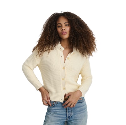 A woman wearing an ivory cardigan and blue jeans