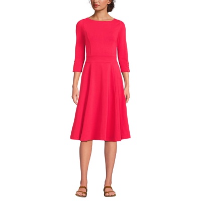 A woman wearing a light pink 3/4 sleeve dress and brown flat sandals