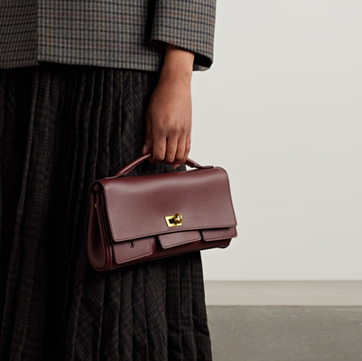 woman holds small burgundy clutch