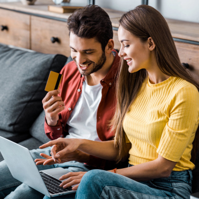 happy married couple reviews their merged finances and shared financial goals on the computer