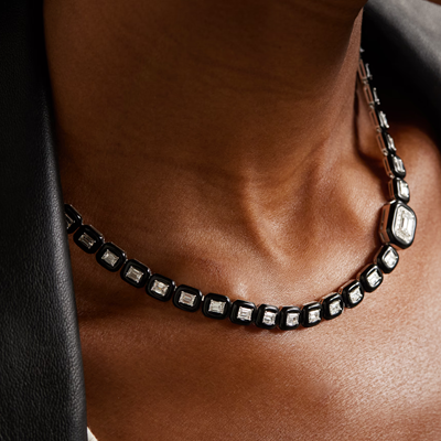 black enamel and diamond necklace, pictured against a Black model's neck