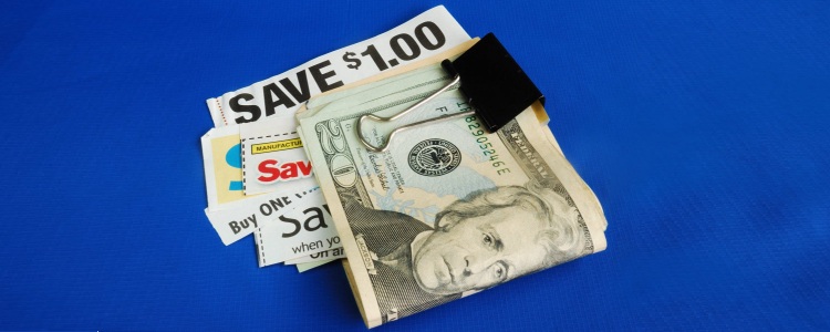 binder clip holds stack of $20 bills and various coupons, part of Elizabeth's tips for money saving habits!