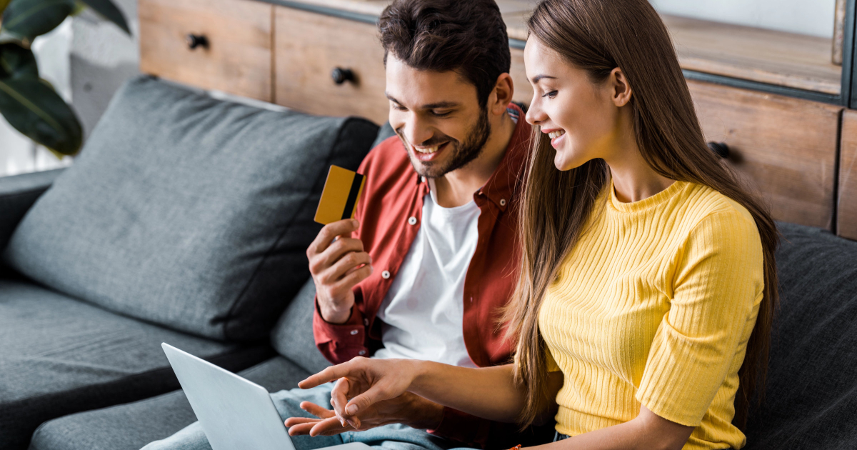 happy married couple reviews their merged finances and shared financial goals on the computer