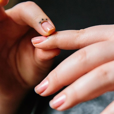 A woman applying cuticle butter to her hands