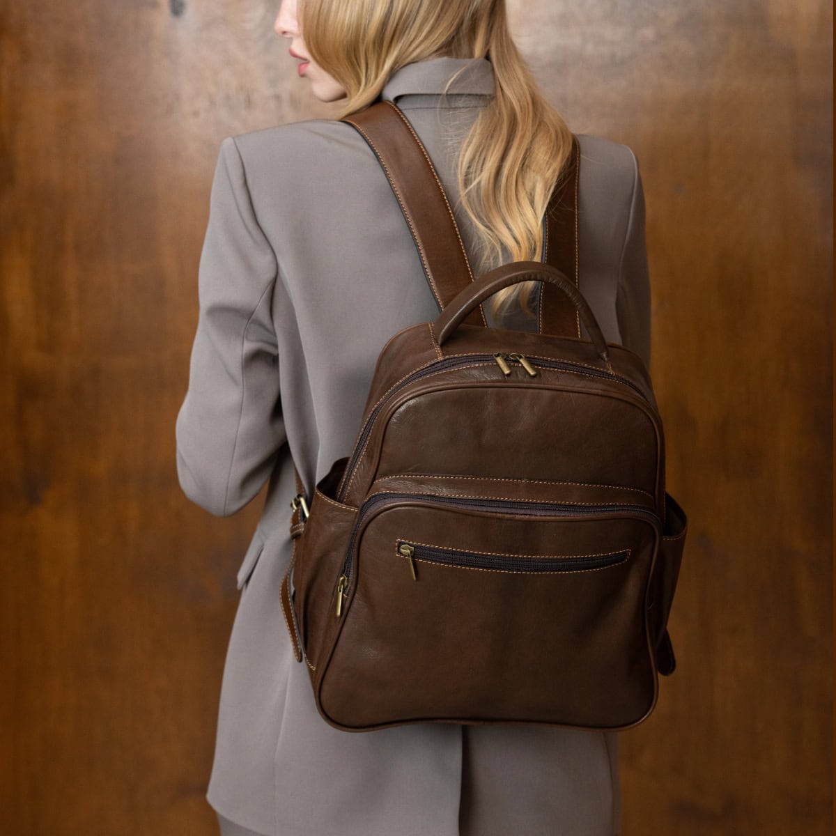 stylish professional woman wears mushroom colored suit and a dark brown backpack