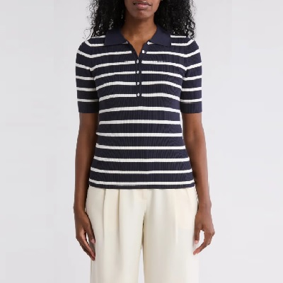A woman wearing a blue white stripe polo shirt and white pants