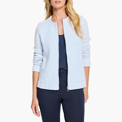 A woman wearing navy pants, a baby blue jacket, and navy top