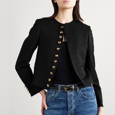 A woman wearing a black top with black twill jacket and denim pants