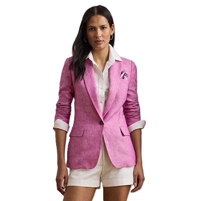A woman wearing a pink linen blazer, a white button-front, and white shorts, plus a pocket square