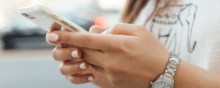 woman wearing white nail polish types on her phone, she just might be creating a best prices list or spreadsheet