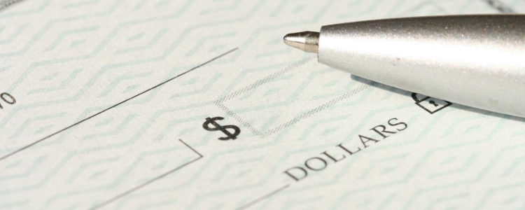 pen hovers above blank check